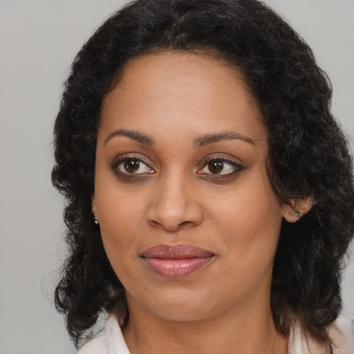 Joyful black young-adult female with long  brown hair and brown eyes