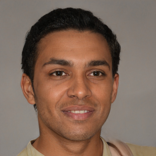Joyful latino young-adult male with short  brown hair and brown eyes