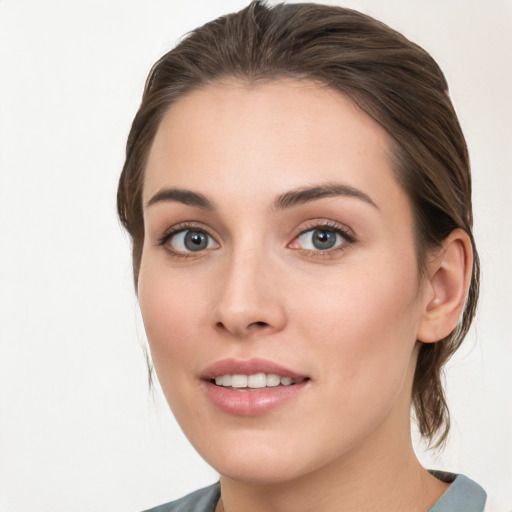 Joyful white young-adult female with medium  brown hair and blue eyes