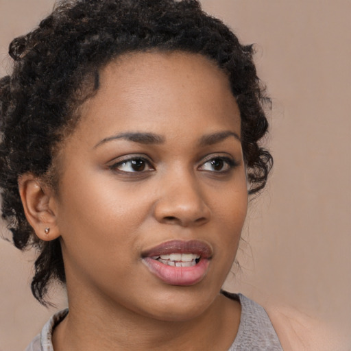 Joyful black young-adult female with long  brown hair and brown eyes