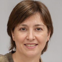 Joyful white adult female with medium  brown hair and grey eyes