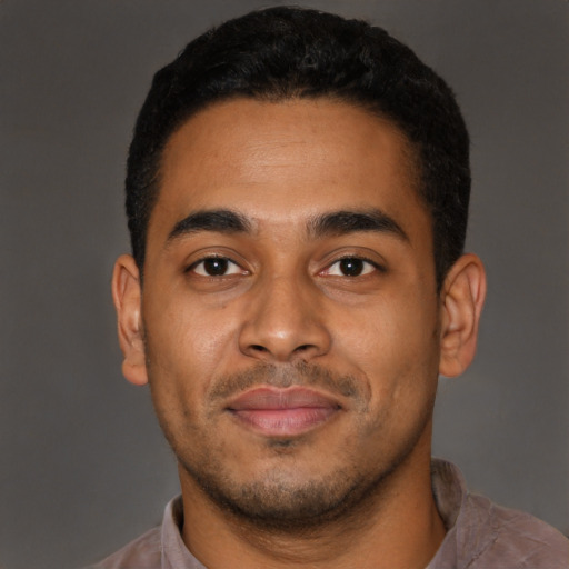 Joyful latino young-adult male with short  brown hair and brown eyes