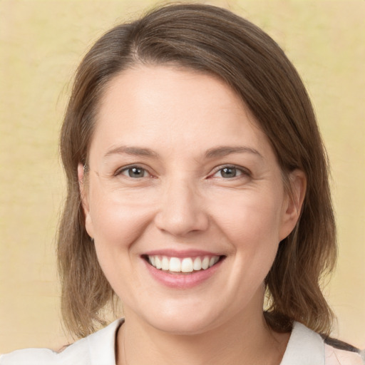 Joyful white young-adult female with medium  brown hair and green eyes