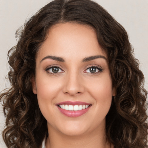 Joyful white young-adult female with long  brown hair and brown eyes