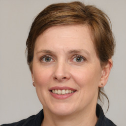 Joyful white adult female with medium  brown hair and grey eyes