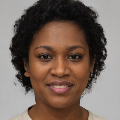Joyful black young-adult female with short  brown hair and brown eyes