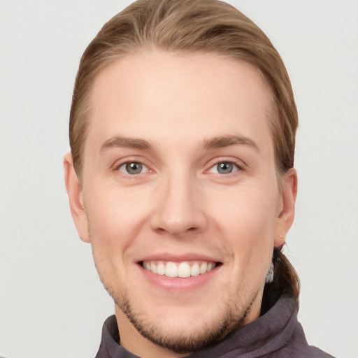 Joyful white young-adult male with short  brown hair and grey eyes