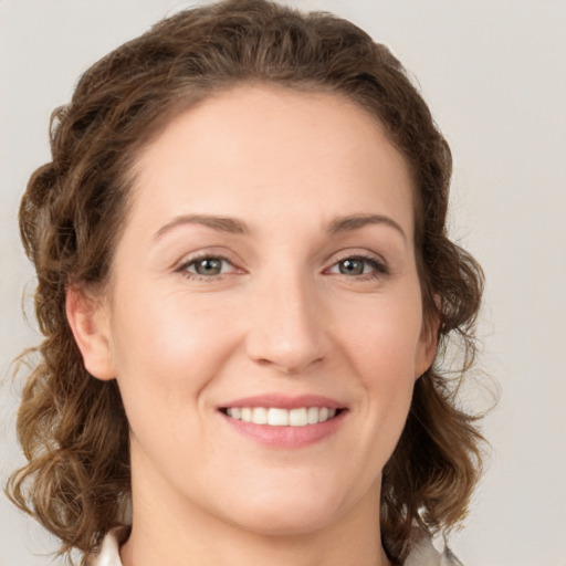 Joyful white young-adult female with medium  brown hair and green eyes