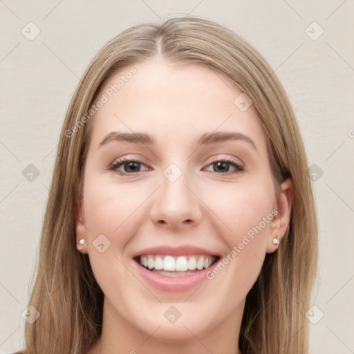 Joyful white young-adult female with long  brown hair and blue eyes