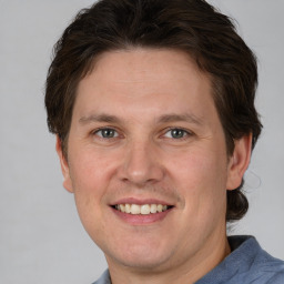 Joyful white adult male with short  brown hair and grey eyes