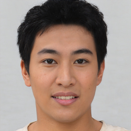 Joyful asian young-adult male with short  black hair and brown eyes
