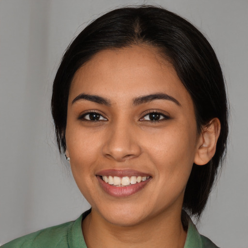 Joyful latino young-adult female with medium  black hair and brown eyes