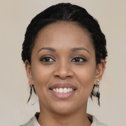 Joyful black young-adult female with short  black hair and brown eyes