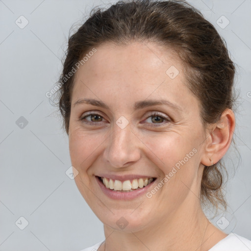 Joyful white adult female with medium  brown hair and grey eyes