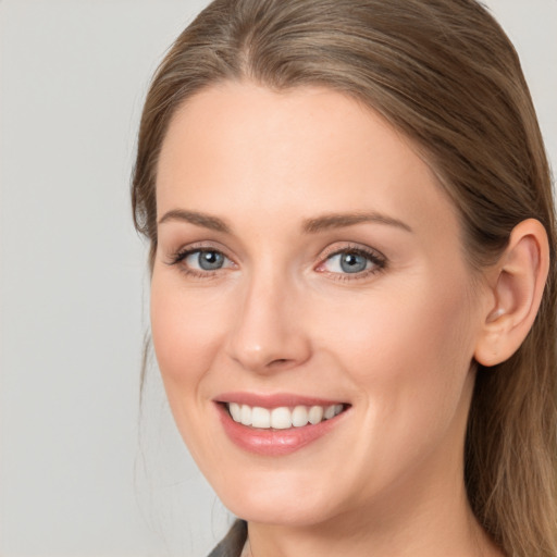 Joyful white young-adult female with long  brown hair and blue eyes