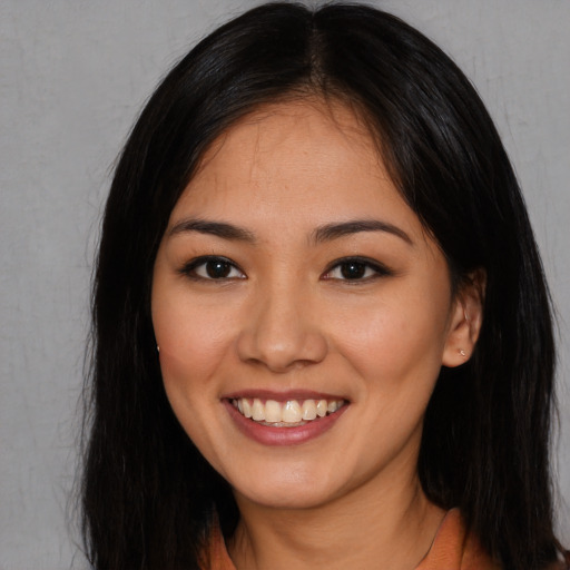 Joyful asian young-adult female with long  brown hair and brown eyes