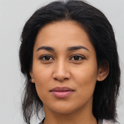 Joyful latino young-adult female with medium  brown hair and brown eyes