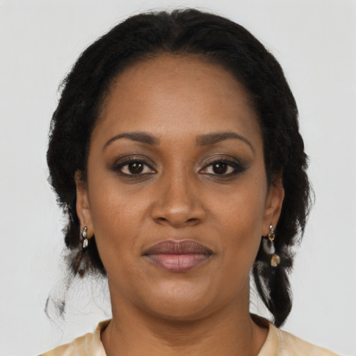 Joyful black young-adult female with long  black hair and brown eyes