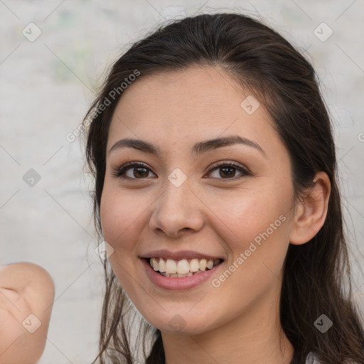 Joyful white young-adult female with long  brown hair and brown eyes