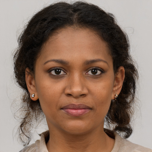 Joyful black young-adult female with medium  brown hair and brown eyes