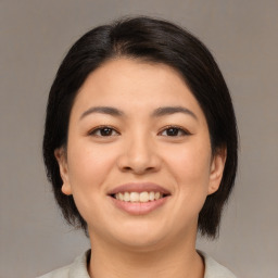 Joyful asian young-adult female with medium  brown hair and brown eyes