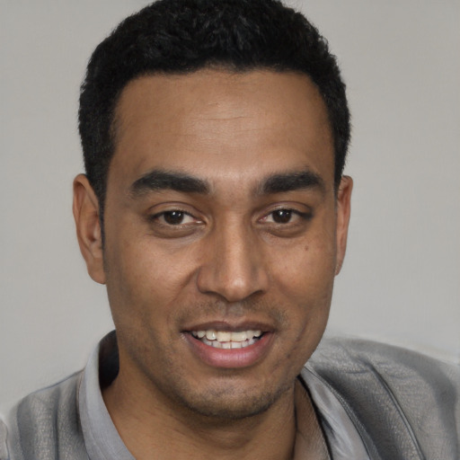 Joyful black young-adult male with short  black hair and brown eyes