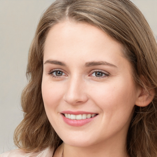 Joyful white young-adult female with long  brown hair and blue eyes