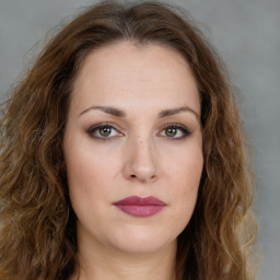 Joyful white young-adult female with long  brown hair and green eyes