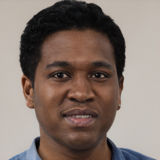 Joyful black young-adult male with short  black hair and brown eyes