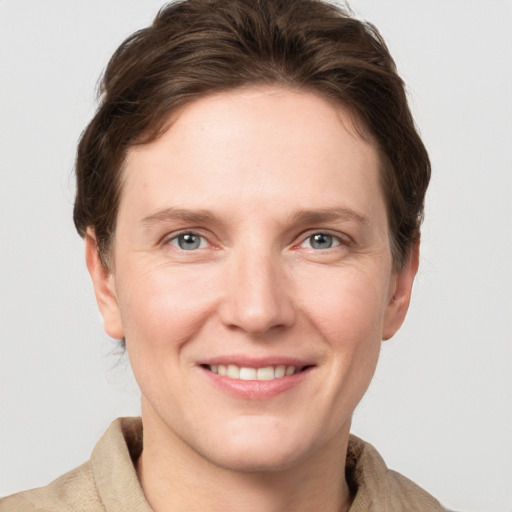 Joyful white young-adult female with short  brown hair and grey eyes