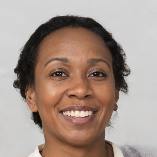 Joyful black adult female with short  brown hair and brown eyes