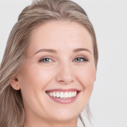 Joyful white young-adult female with long  brown hair and blue eyes