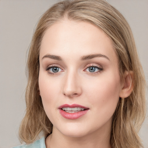 Joyful white young-adult female with long  brown hair and blue eyes