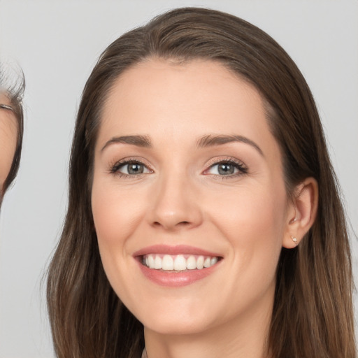 Joyful white young-adult female with long  brown hair and brown eyes