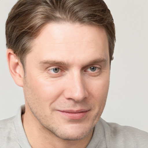 Joyful white young-adult male with short  brown hair and grey eyes