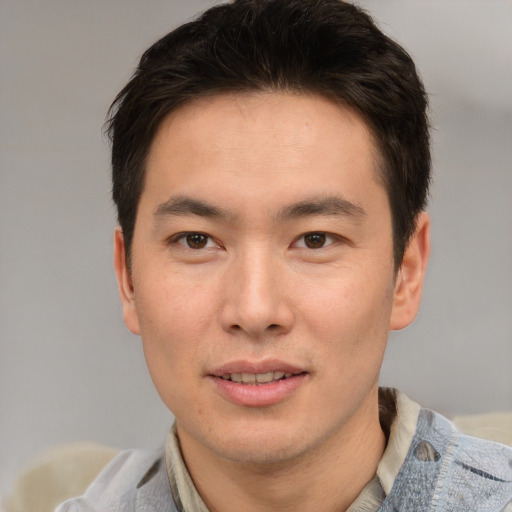 Joyful asian young-adult male with short  brown hair and brown eyes