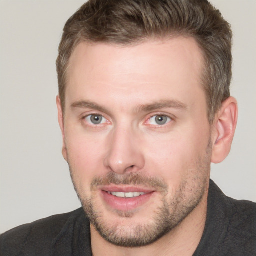 Joyful white adult male with short  brown hair and blue eyes