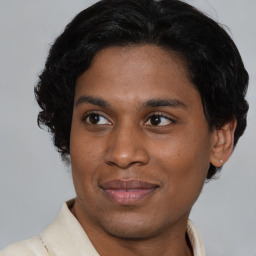 Joyful latino young-adult male with short  brown hair and brown eyes