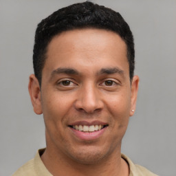 Joyful latino young-adult male with short  brown hair and brown eyes