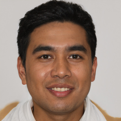 Joyful latino young-adult male with short  black hair and brown eyes