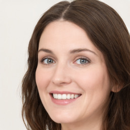 Joyful white young-adult female with long  brown hair and green eyes