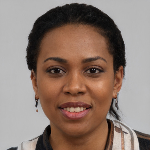 Joyful black young-adult female with short  black hair and brown eyes