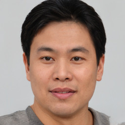 Joyful asian young-adult male with short  black hair and brown eyes