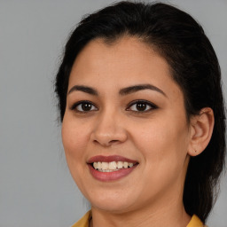 Joyful latino young-adult female with medium  brown hair and brown eyes