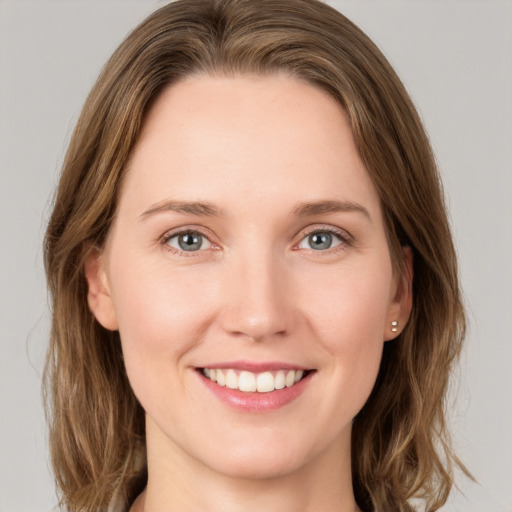 Joyful white young-adult female with medium  brown hair and grey eyes