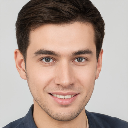 Joyful white young-adult male with short  brown hair and brown eyes