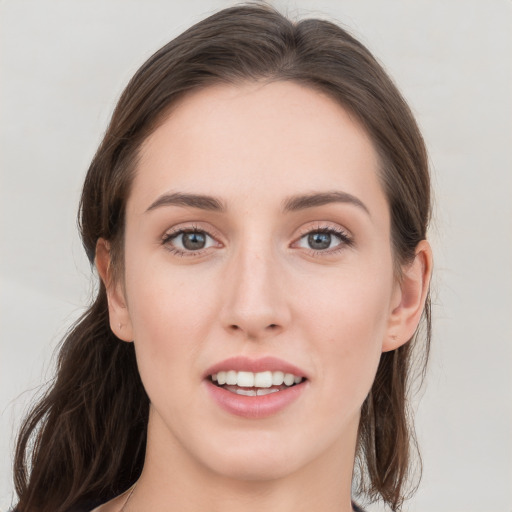 Joyful white young-adult female with medium  brown hair and grey eyes