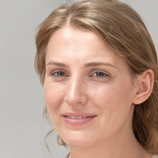 Joyful white adult female with medium  brown hair and grey eyes