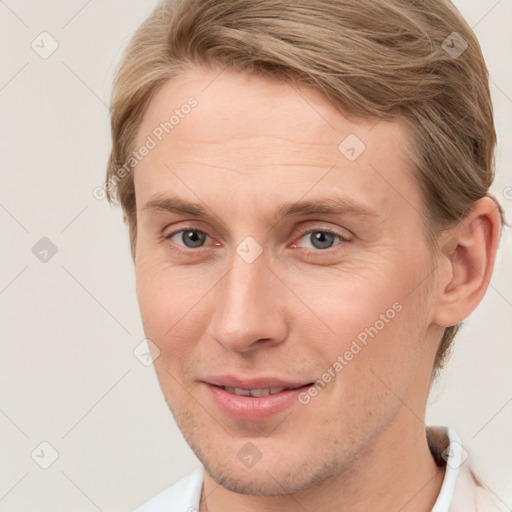 Joyful white young-adult male with short  brown hair and grey eyes