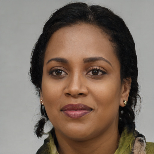 Joyful black young-adult female with long  black hair and brown eyes